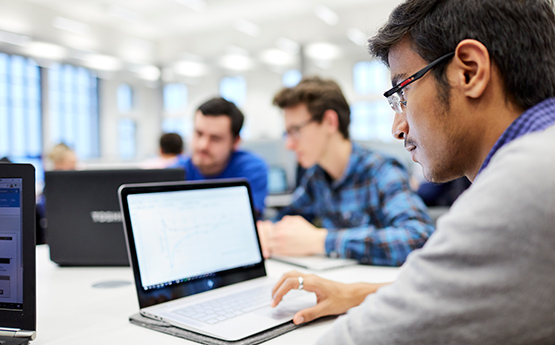 Three male students studying at laptops