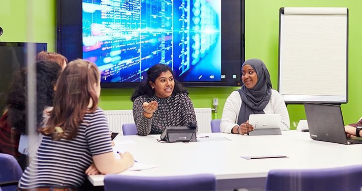 Students around a laptop talking