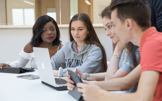 Four students sitting around a computer.