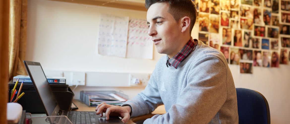 A male student on a laptop