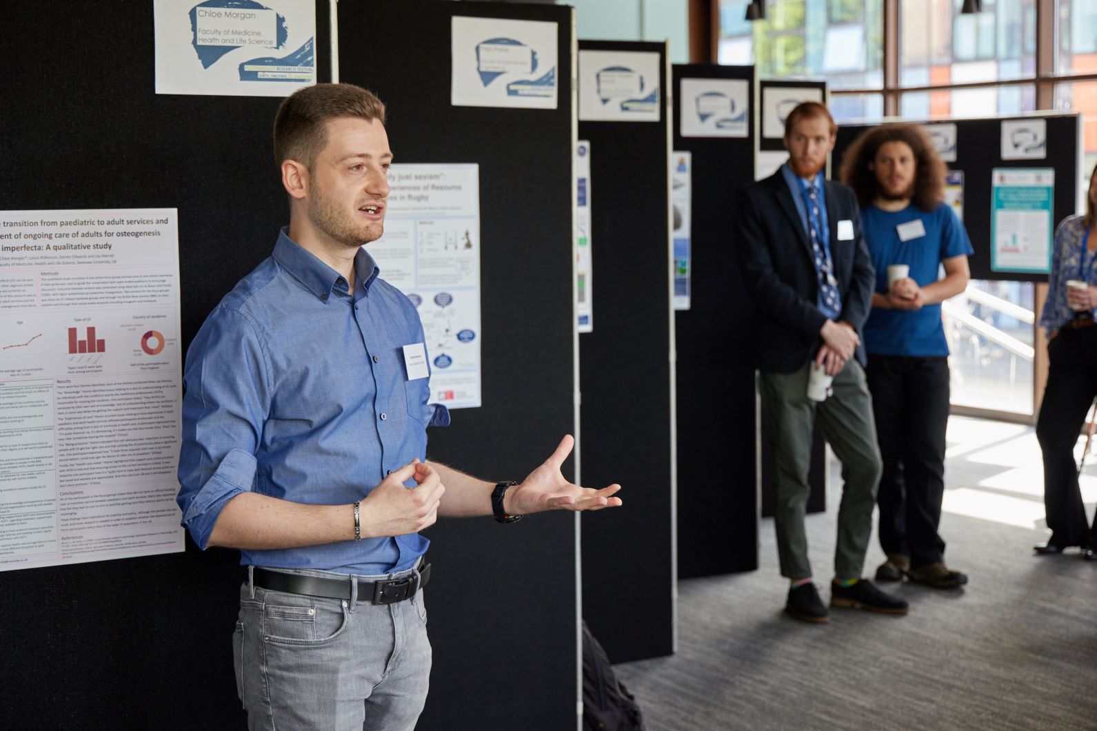 A student standing in front of a poster, presenting